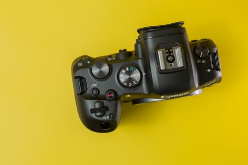 Free Flat lay of a digital camera on a vibrant yellow background, perfect for tech themes. Stock Photo