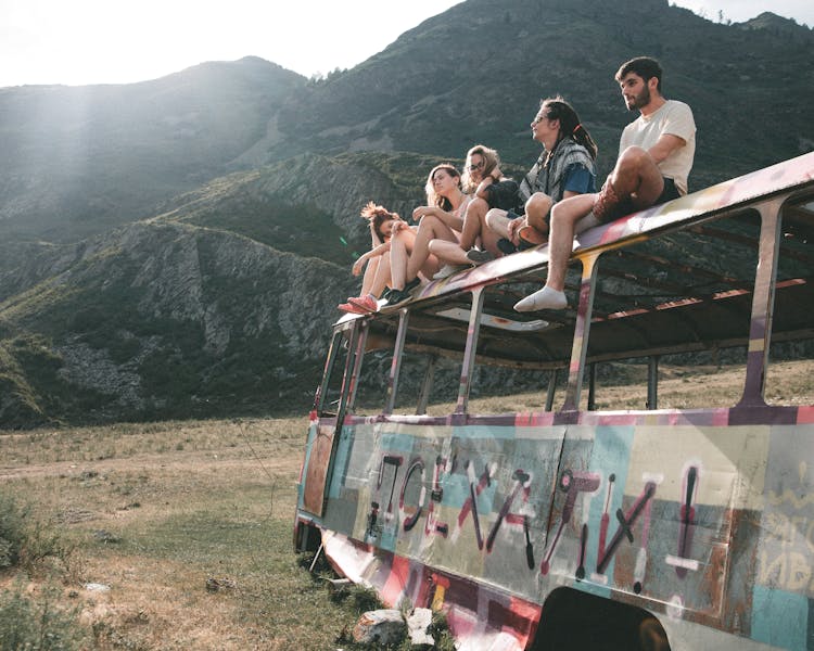 Group Of People Sitting On Abandoned Bus