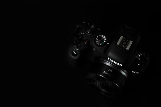 Close-up of a digital camera against a black background, showcasing photographic equipment.