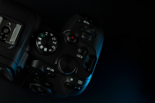 Close-up detail shot of a high-end DSLR camera control panel in moody lighting.