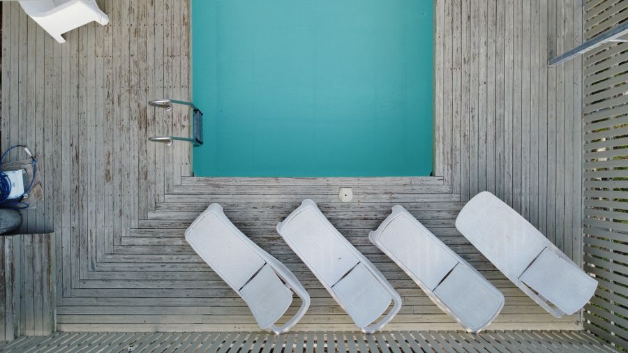 Top-down view of sunbeds beside a pool