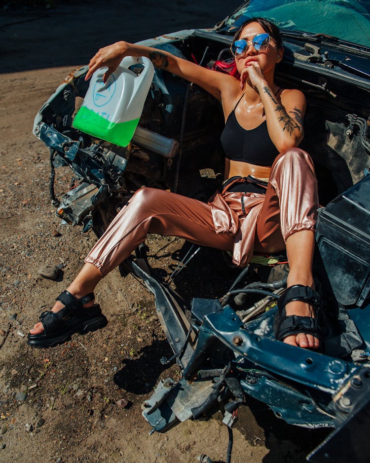 Woman In Sunglasses Sitting In The Trunk Of A Wrecked Car