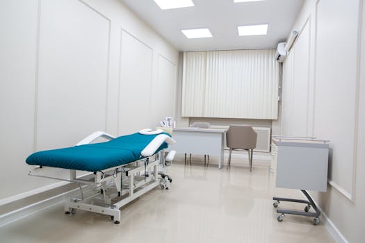A contemporary medical office interior with modern furnishings, treatment bed, and clean design.