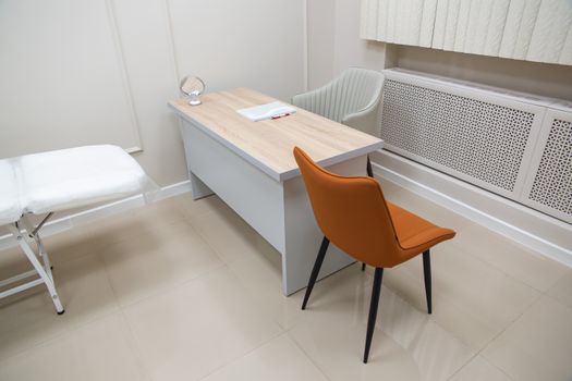 Doradztwo środowiskowe a konsulting ekologiczny – czym się różnią? 2 Minimalist office interior featuring a desk with chairs, suitable for healthcare or office settings.