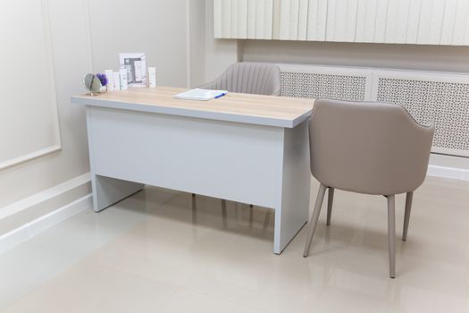 Stylish office setup featuring a modern desk with elegant chairs and minimal decor.