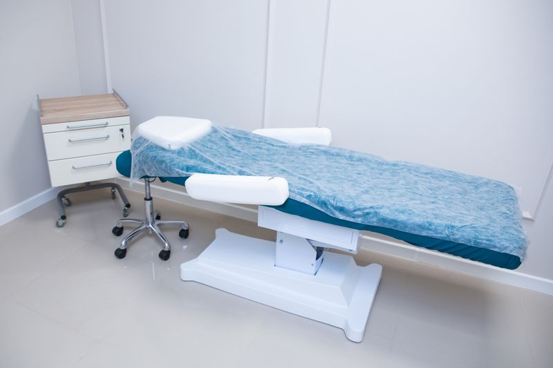 Sterile and modern medical examination room featuring adjustable bed and cabinet