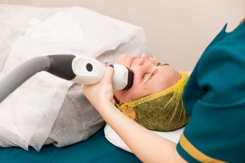 Free A woman receiving professional facial treatment at a clinic, highlighting beauty and technology. Stock Photo