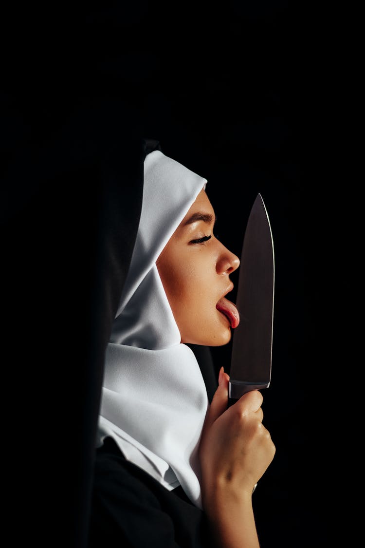 Woman In Hijab Licking A Knife