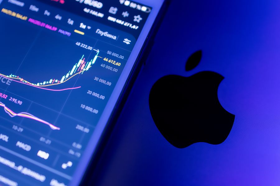 A close-up of an Apple device displaying stock market graphs, indicating economic trends.