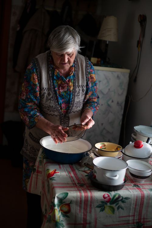 Free Elderly woman preparing food in a homely kitchen setting, showcasing traditional cooking style. Stock Photo