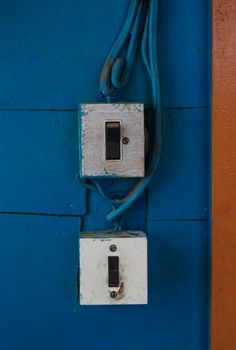 Vintage electrical switches on a rustic wall.