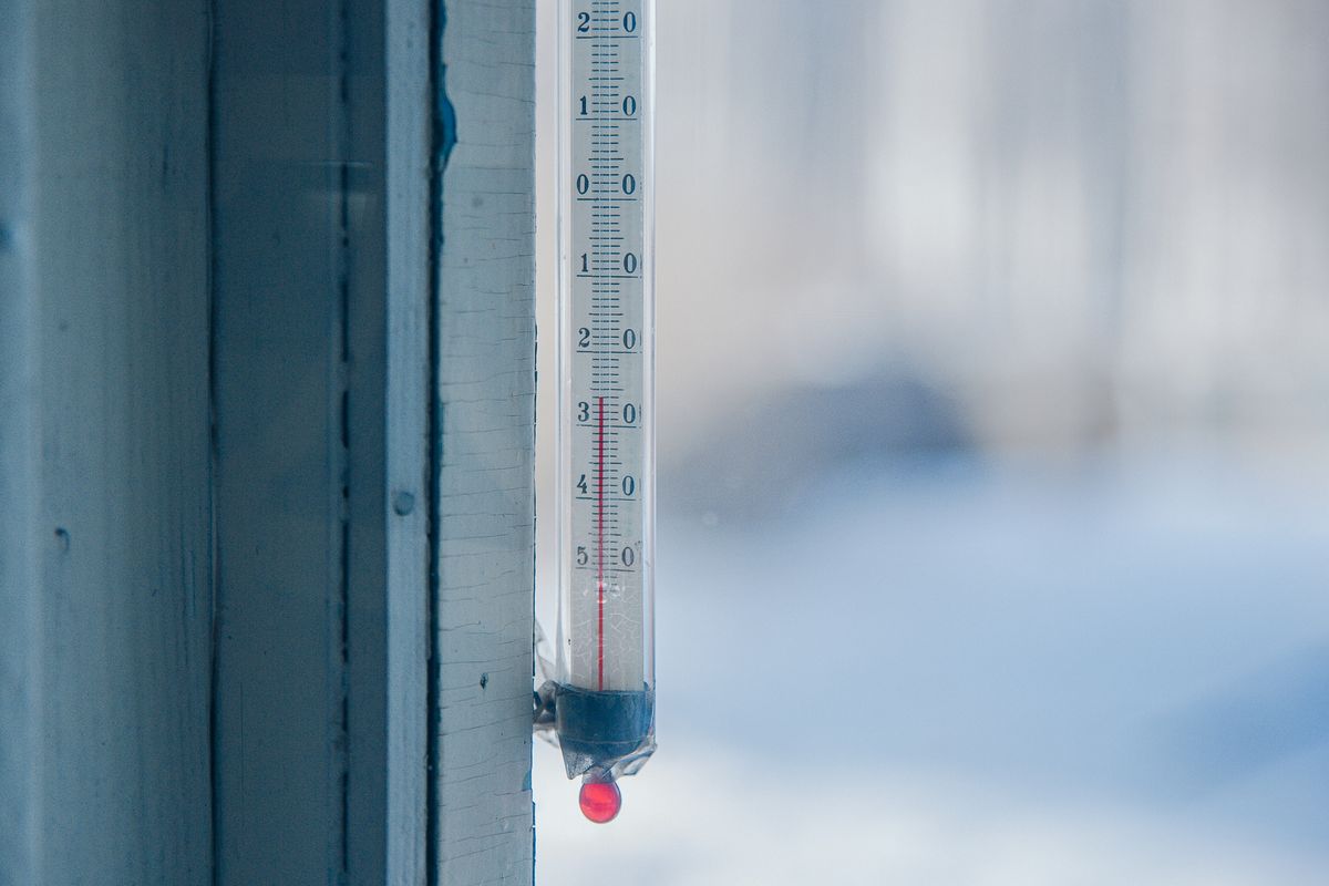 Close-up of an outdoor thermometer against a frosty winter backdrop