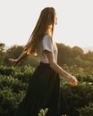 Unrecognizable woman walking among plants
