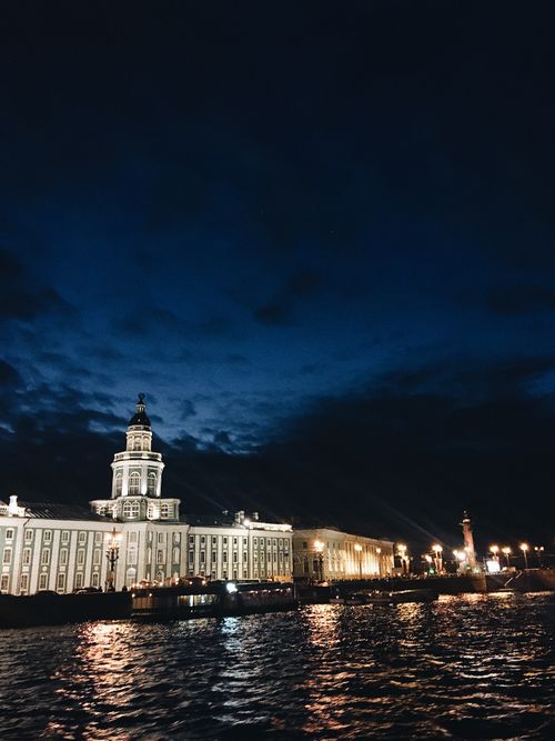 Free Illuminated classic buildings located on coast of canal against dark cloudy sky at night in historic city Stock Photo