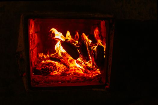 Warm indoor fireplace with crackling firewood and vivid flames creating a cozy atmosphere.