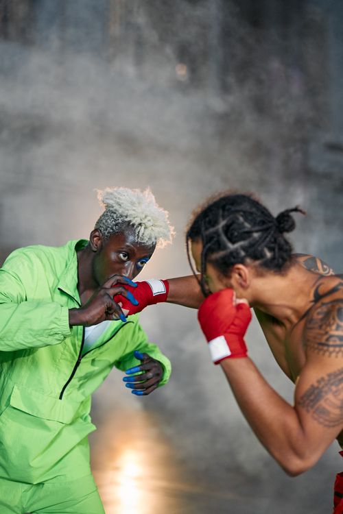 Free Two men engage in an intense sparring session with a dramatic smoke-filled backdrop. Stock Photo