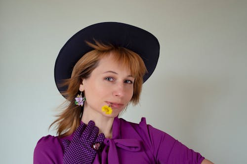 Close-Up Photo of a Beautiful Woman with a Yellow Flower in Her Mouth