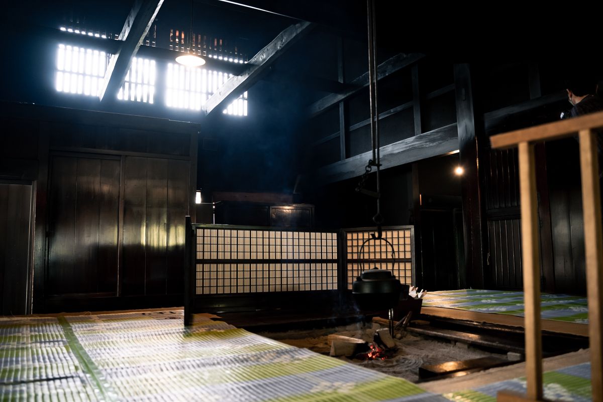 Interior of a traditional Japanese ryokan room with tatami floor, low table, and shoji screens