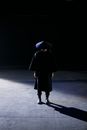 Woman in Black Coat Walking on Gray Concrete Floor