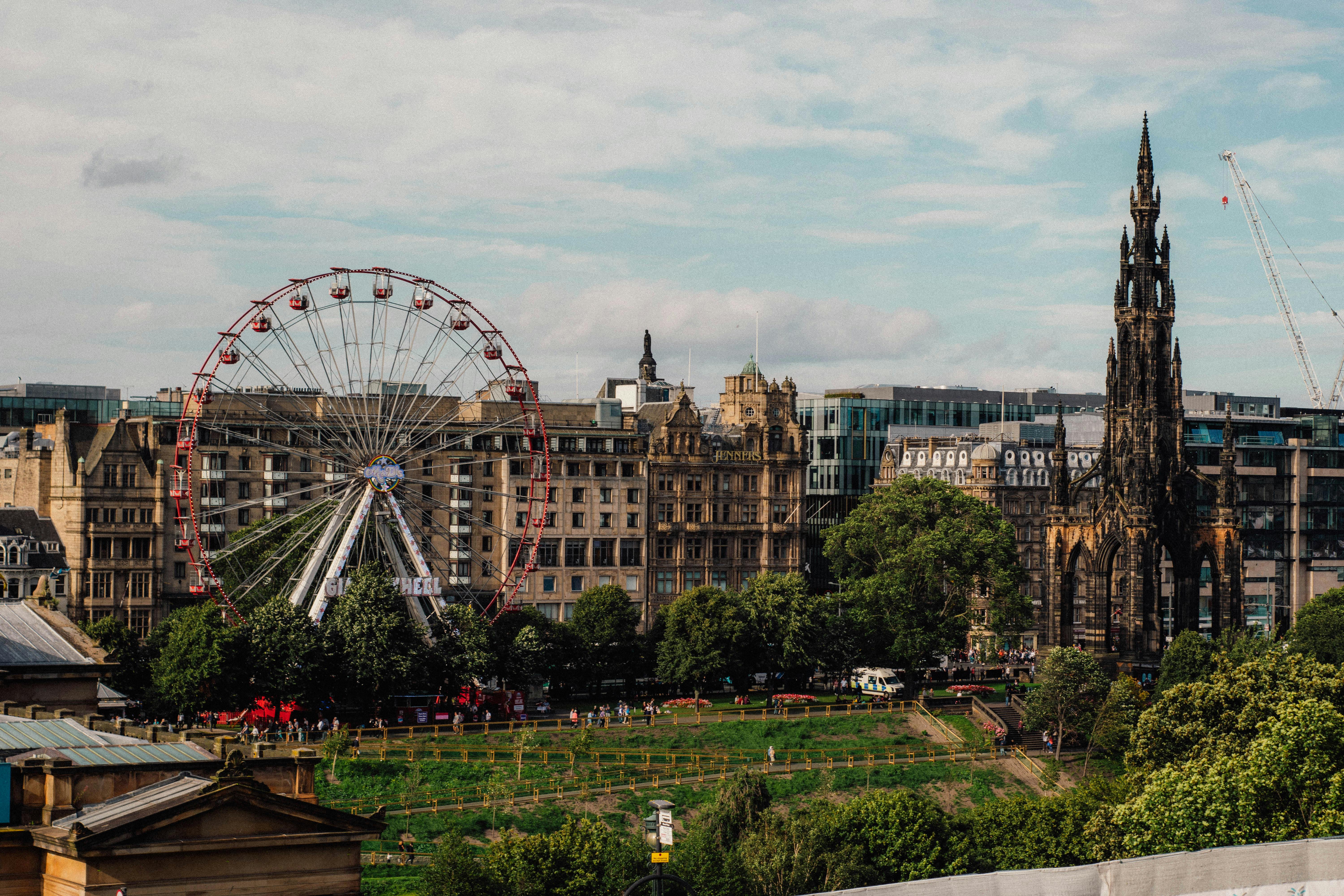 photo of the ferris wheel and the scott monument in edinburgh scotland uk