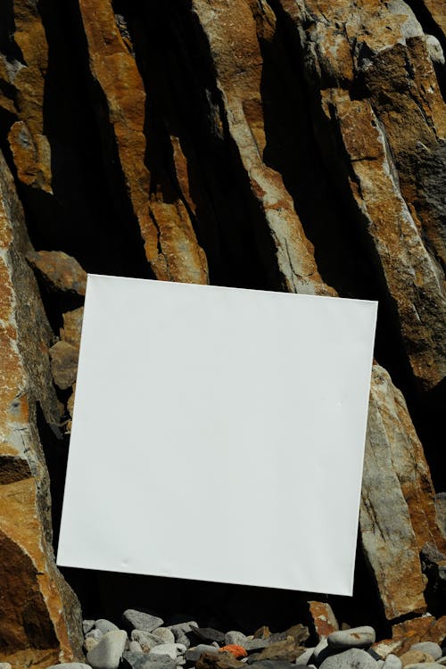 White Printer Paper on Brown Rock
