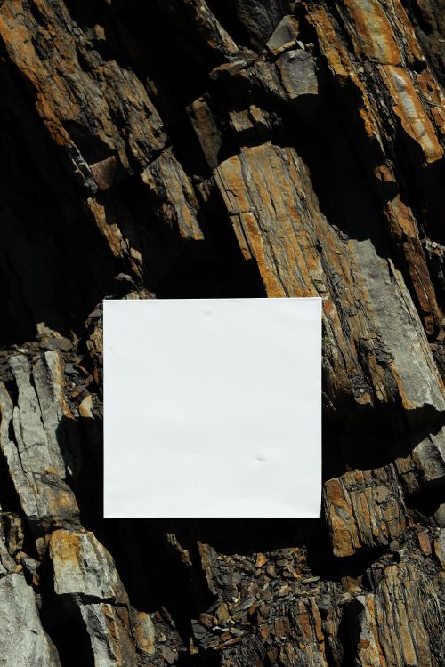 Free A square white paper with copy space placed on rugged rock textures. Stock Photo