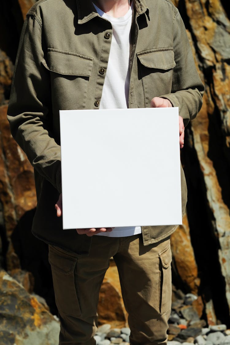 Man In Khaki Clothes Holding White Square Box