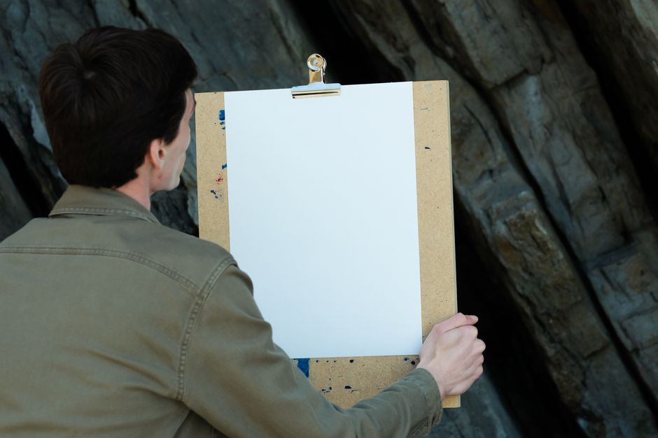 Painting contractor writing a painting estimate on a clipboard at a job site