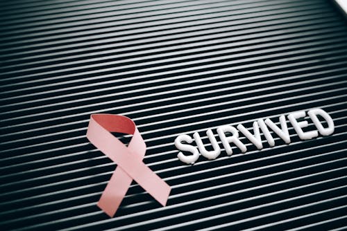 A Pink Ribbon Beside a Note on a Letter Board
