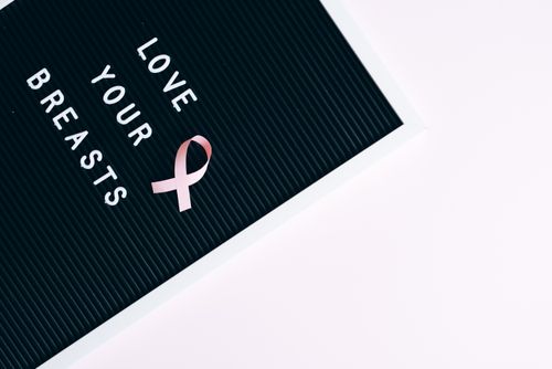 Free Inspirational letter board with pink ribbon promoting breast cancer awareness and self-love. Stock Photo