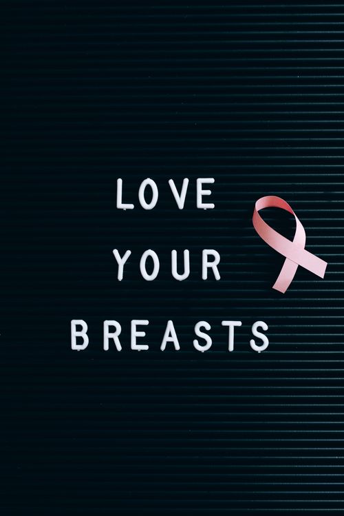 Free Inspirational breast cancer awareness message with a pink ribbon on a letter board. Stock Photo