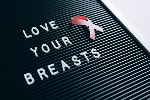 Free Close-up of a letter board with 'Love Your Breasts' message and pink ribbon for breast cancer awareness. Stock Photo