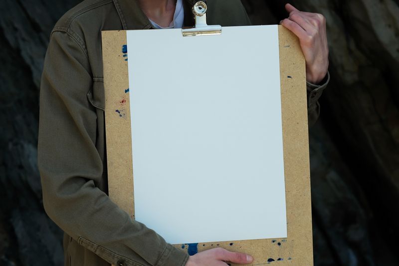Person holding a freshly printed sheet on a clipboard — photo by Nadezhda Moryak on Pexels