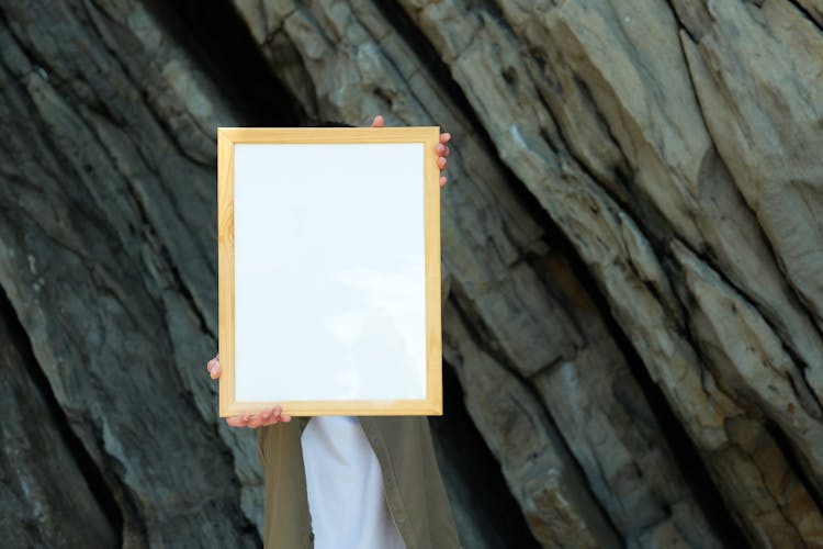 A Person Holding A Blank Wooden Frame