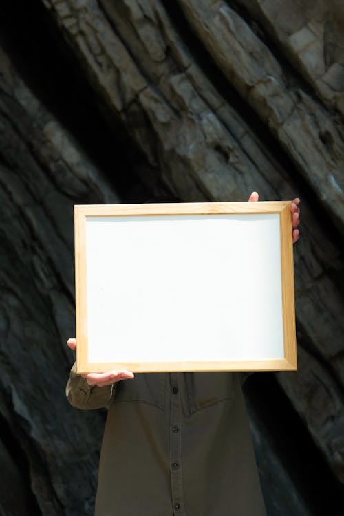 A  Person Holding Brown Wooden Frame