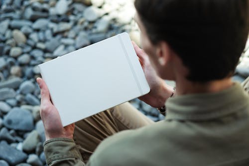 A Person Holding White Notebook