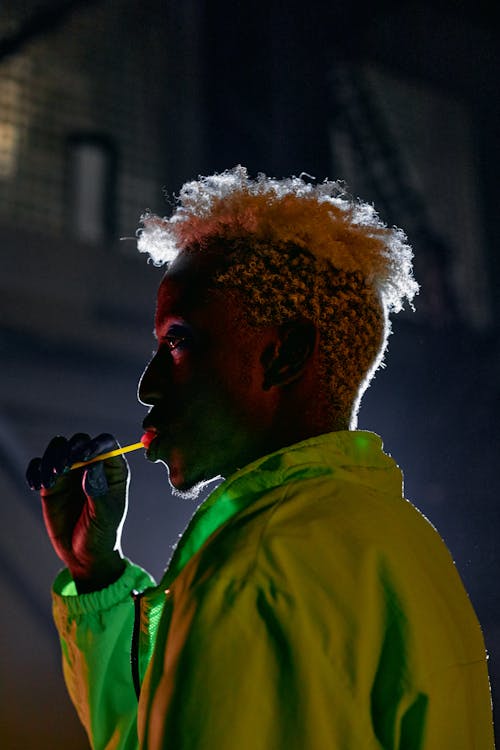 Side View Shot of a Man Licking Lollipop