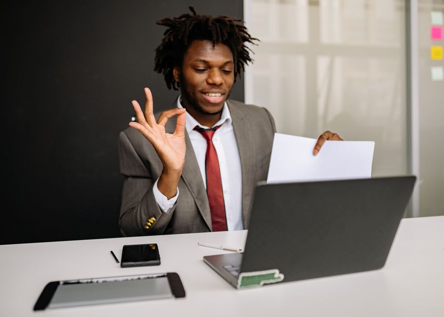 Young businessman conducting an online meeting in an office setting with a laptop.