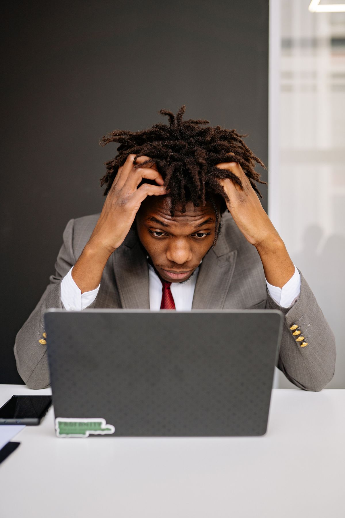Exhausted man working at laptop showing signs of workplace burnout