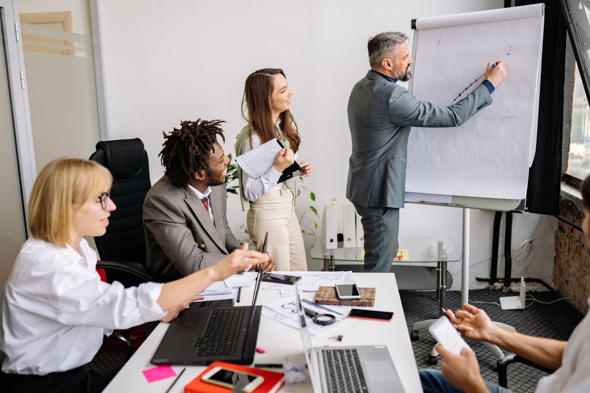 Formateur construisant une progression pédagogique au paperboard devant un groupe