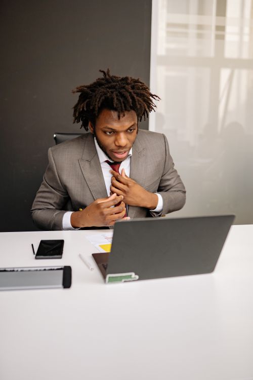 Free A young businessman with dreadlocks works intently on his laptop in a modern office setting. Stock Photo