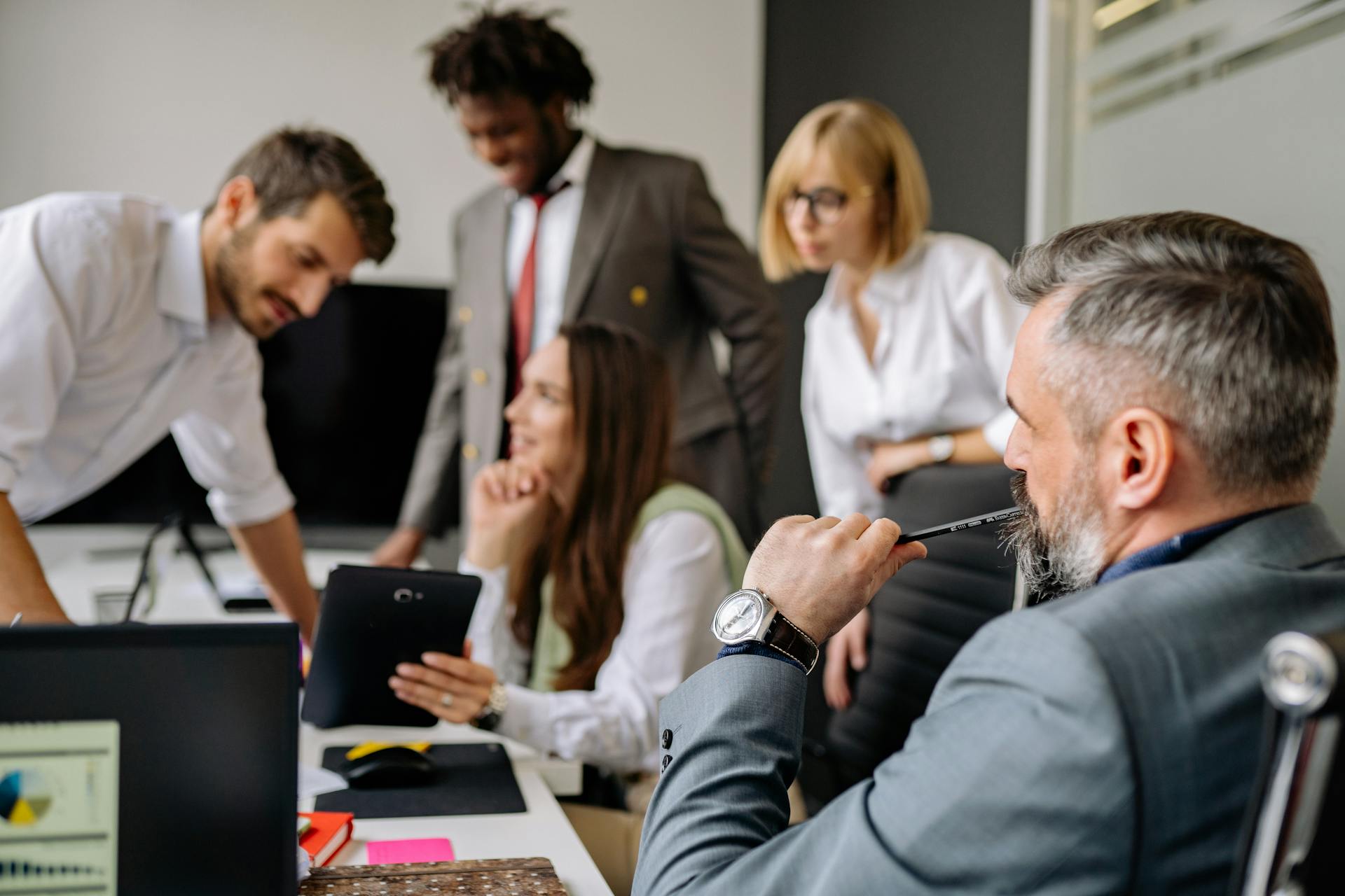 A diverse group of professionals engaging in a collaborative meeting in a modern office setting.