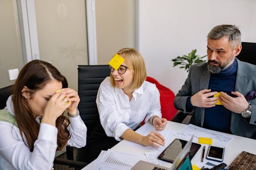 Business colleagues engaging in a fun team building activity with sticky notes in a conference room.