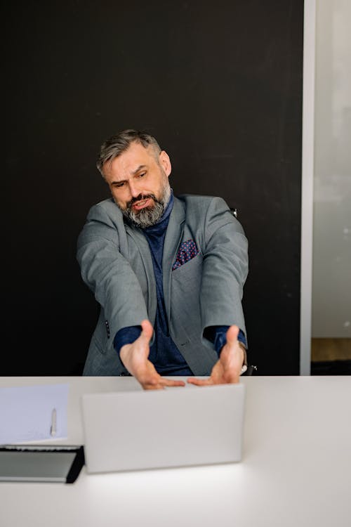 Man in Suit Reacting to Laptop