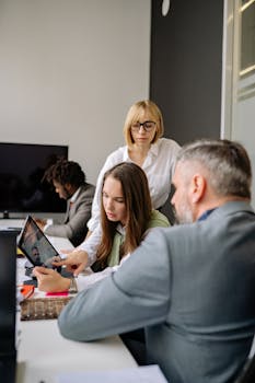 Colleagues engaged in a business meeting, collaborating and discussing strategies in a modern office.