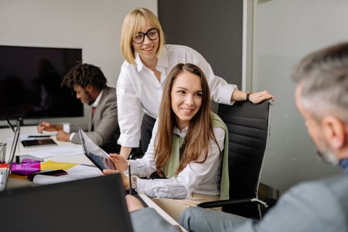 Free A diverse group of professionals engaged in a collaborative office meeting, discussing ideas with technology. Stock Photo