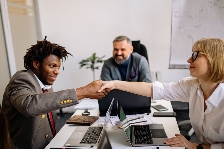 Professional colleagues shaking hands during a successful corporate meeting, showcasing teamwork and cooperation.