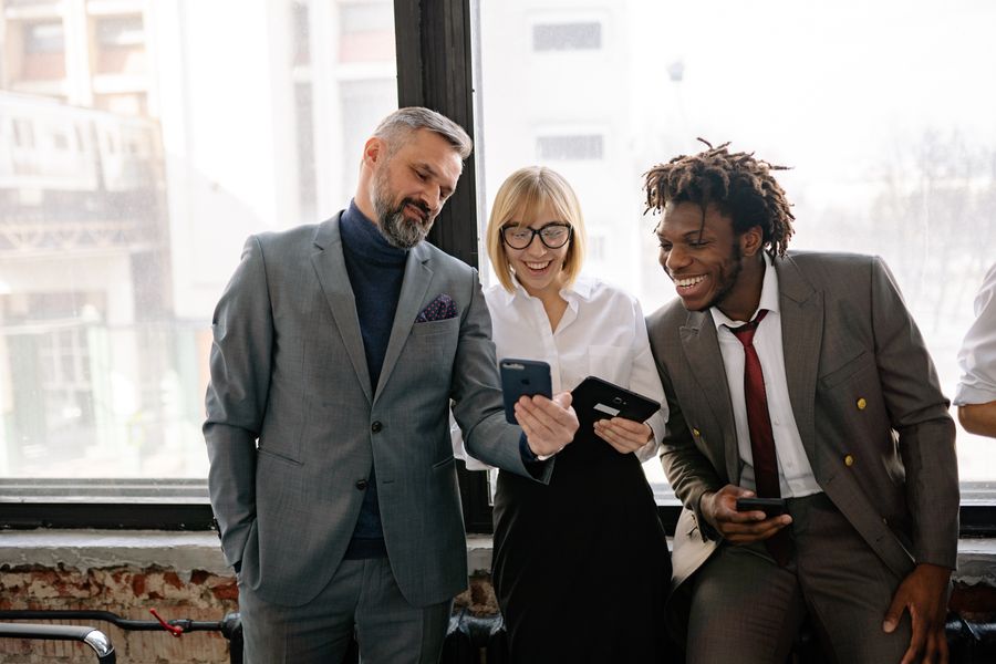 Three colleagues comparing something on their phones — photo by Yan Krukau on Pexels