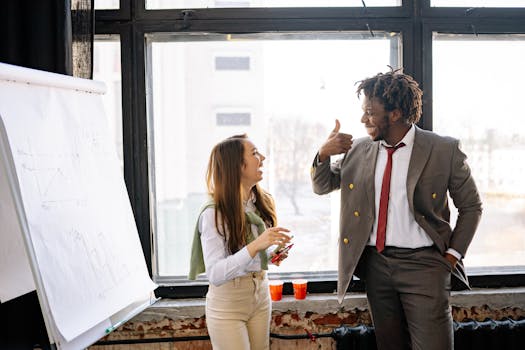 Two business professionals share a moment of success during a meeting, showcasing teamwork and collaboration.