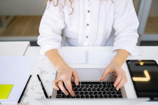 Hands typing on a laptop at a bright desk — photo by Yan Krukau on Pexels